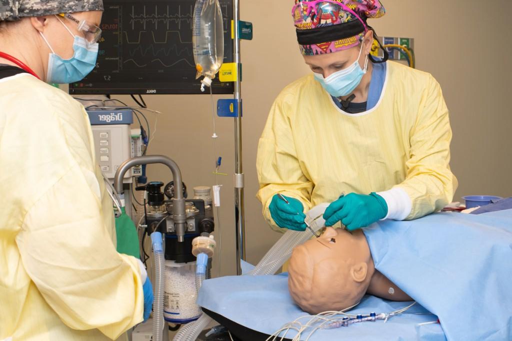 Two Nurse Anesthesia students practicing giving anesthesia on a patient simulator